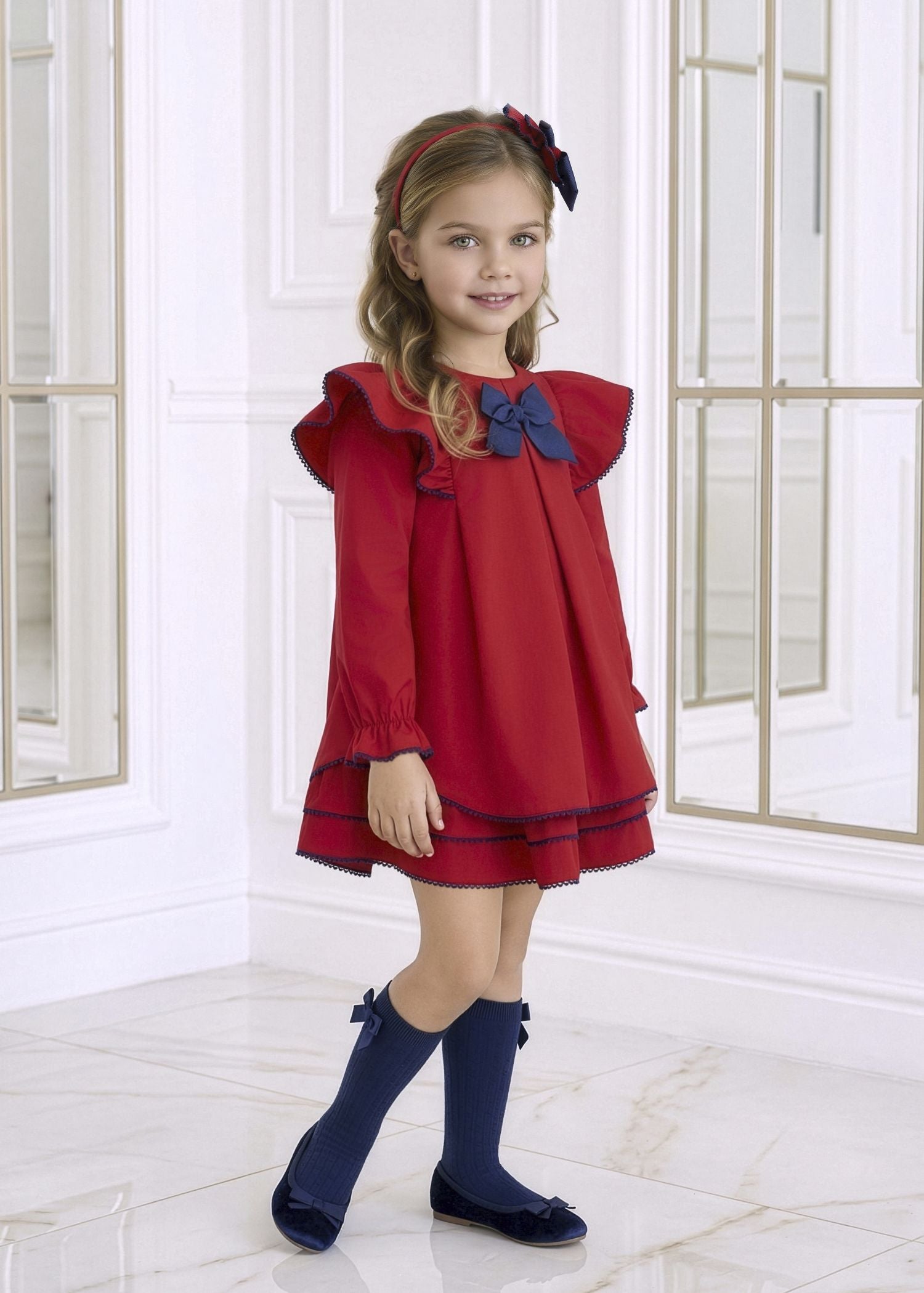Niña luciendo el vestido elegante rojo de invierno con lazo azul marino de la firma española Miranda
