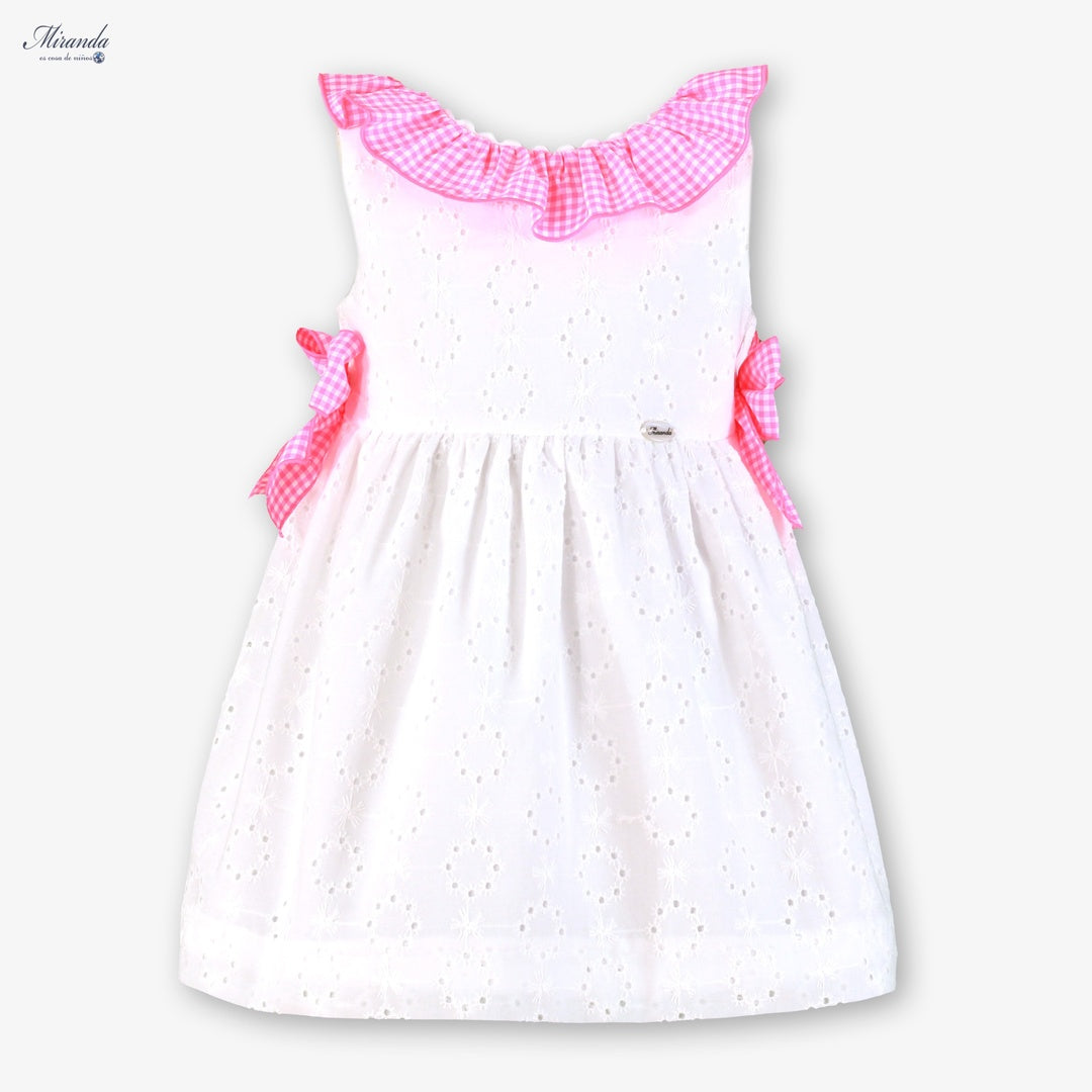 Vestido de ceremonia para niña marca Miranda, blanco bordado perforado con volante de cuadros gingham rosa y lazos laterales.