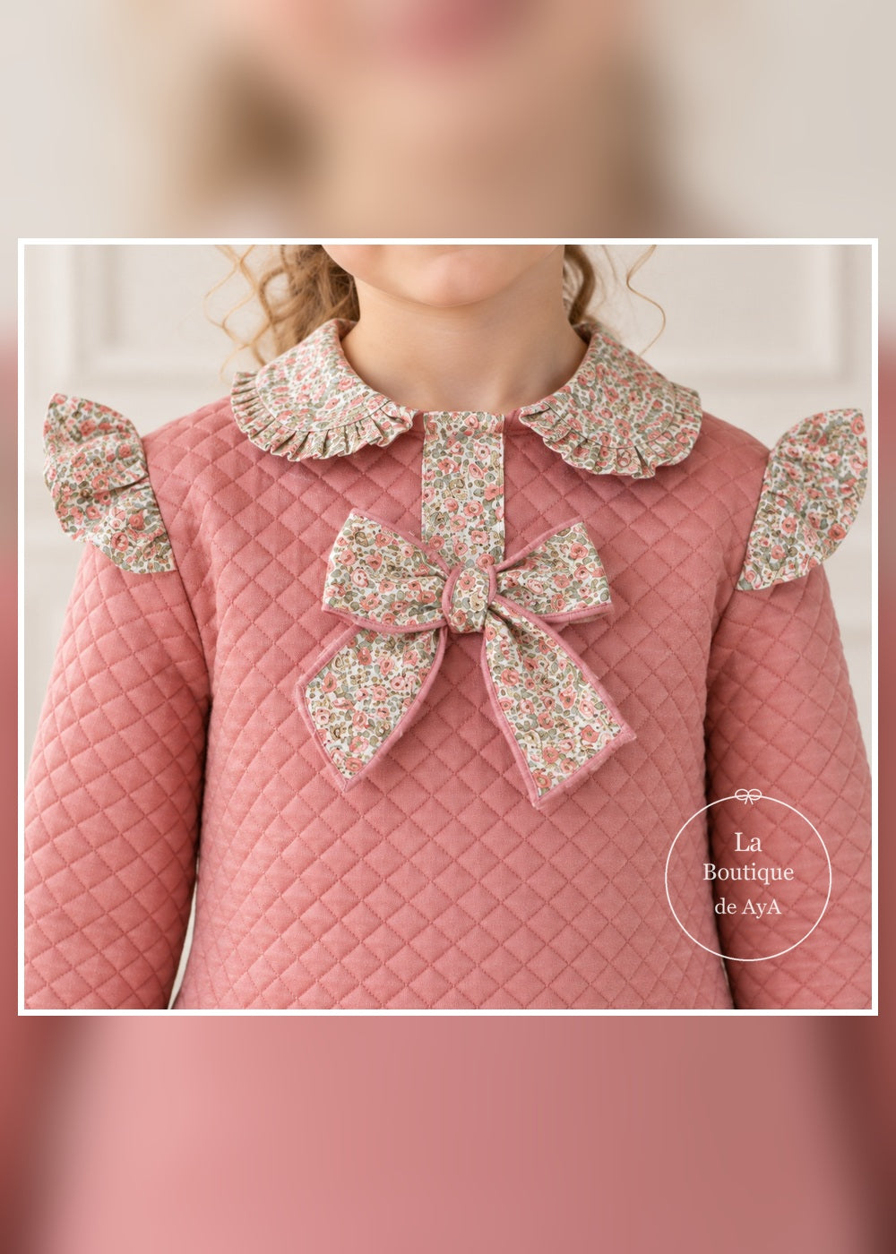 Detalle del cuello floral, lazo y acolchado rosa del vestido Miranda 400616V