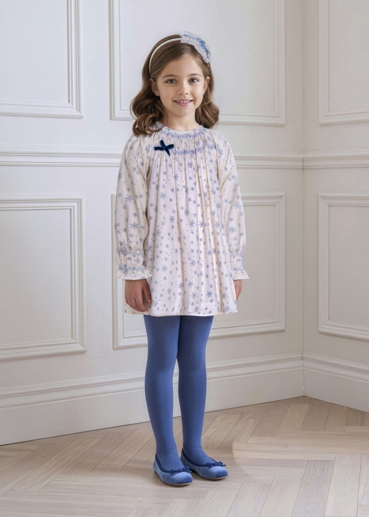 Niña luciendo el dulce vestido de invierno crudo con estampado de copos de nieve de la firma española Miranda